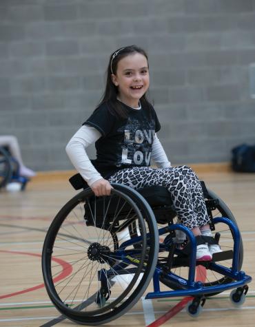 Smiling youth in wheelchair in gymnasium