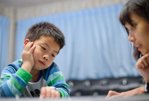 Little boy sad sitting at a table