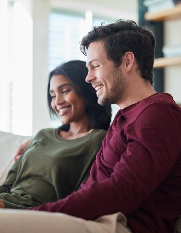 A smiling couple at a laptop