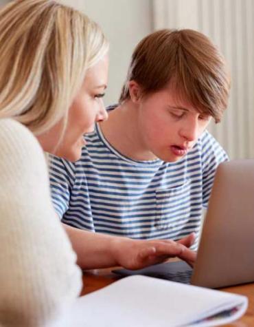 Youth on computer with assistance from mother