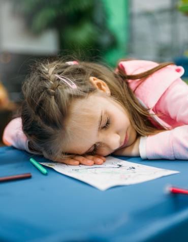 Young girl sleeping on her desk