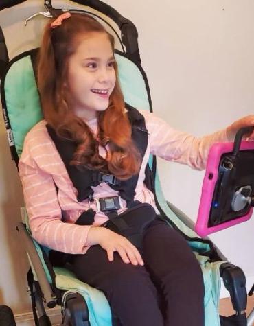 young girl in wheelchair with communication device