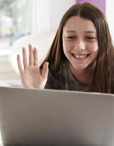 teen waving to friends online