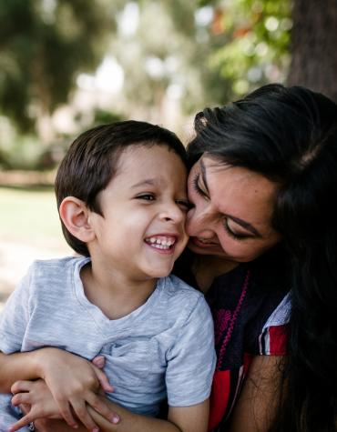 Child and adult smiling and hugging