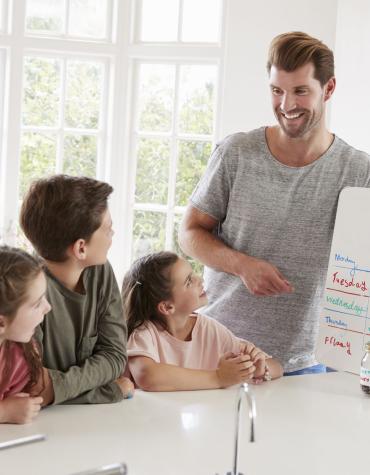 Dad and kids with white board