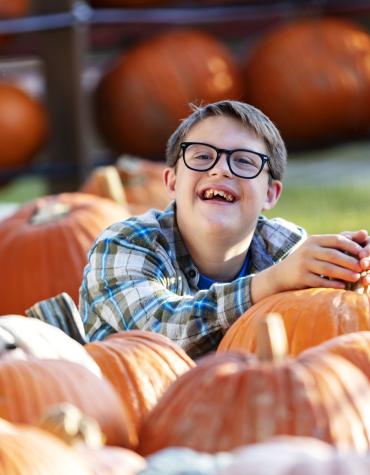 Youth smiling in pumpkin patch