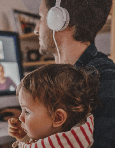 Father attending meeting on laptop