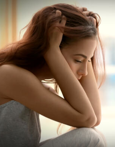 Girl sitting with head in hands and adult hand extended