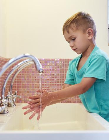 garçon se lavant les mains dans les toilettes