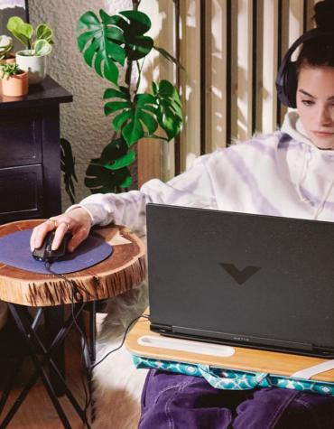 teen playing minecraft on laptop