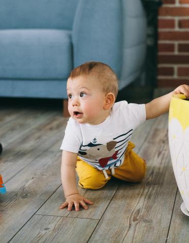 Baby crawling and playing with toy on the ground