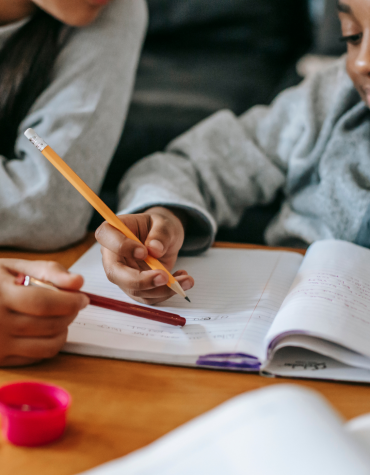 Child completing school work with help from adult