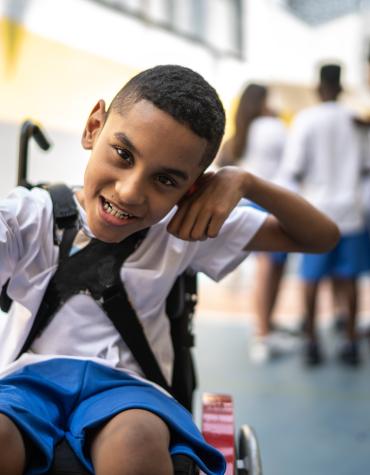 child in a wheelchair posing with punching motion 