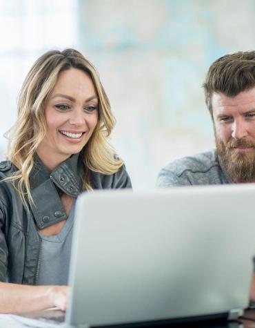 Two adults joining a virtual presentation on a laptop