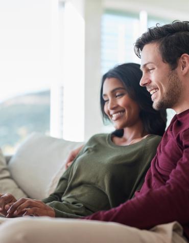 Two adults looking at a laptop and smiling 