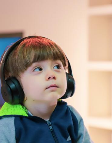 young child listening to headphones