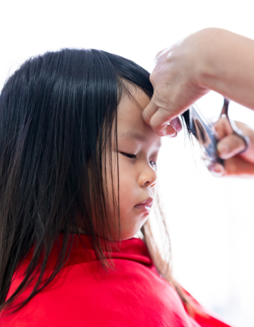 Young girl getting her bangs trimmed