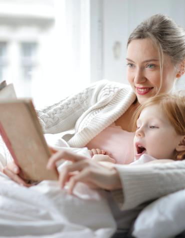 child and adult reading book together