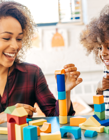 Child and adult playing with blocks together