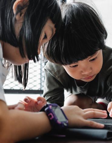 Two young children using iPad