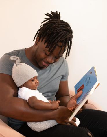 Adult and baby reading together in an armchair