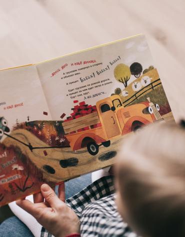 Adult and child reading a book together