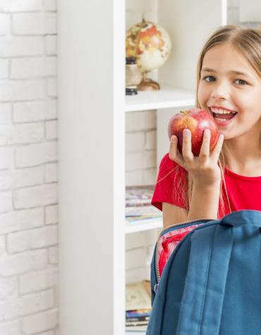 girl after school eating an apple
