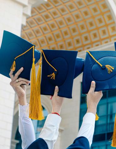 Grad caps held up in the air