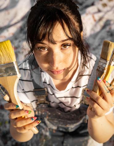Girl holding paint brushes