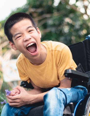 Boy in wheelchair having fun in outdoor setting