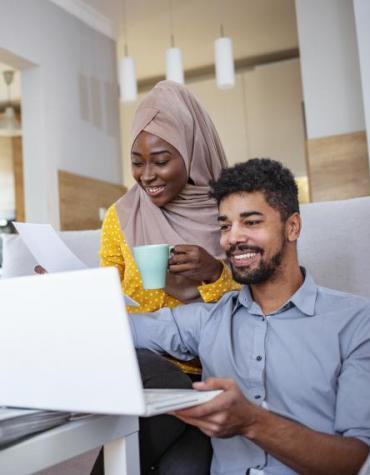 Smiling couple working at a laptop