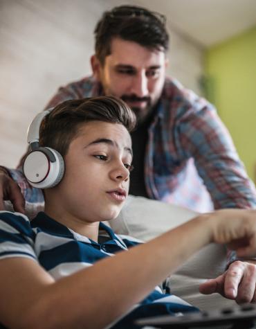 Youth showing adult something on a laptop