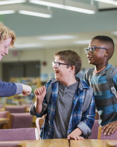 three students fist bumping