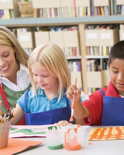 kids painting with teacher